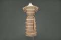Image of Beige metallic dress, modeled in the Seattle World's Fair Fashion Pavilion, 1962